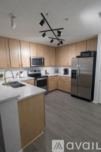 A kitchen with wooden cabinets and a stainless steel refrigerator.