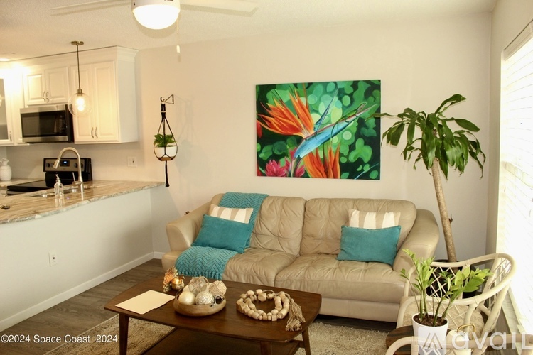 A living room with a couch, a coffee table, and a painting on the wall.