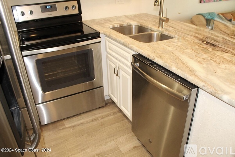 A kitchen with a stainless steel dishwasher and oven.
