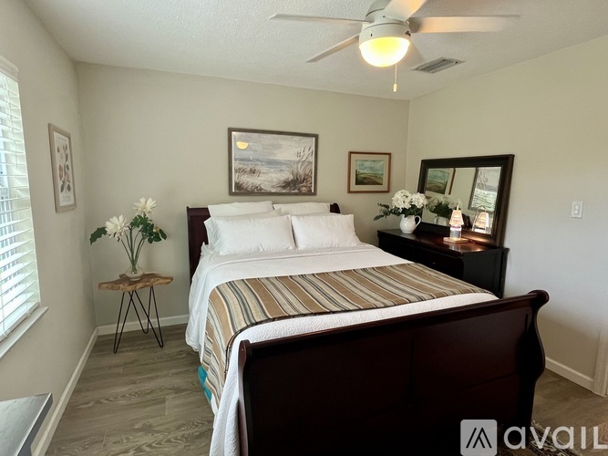 A bedroom with a bed, nightstand, and a ceiling fan.