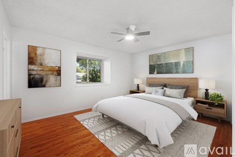 A bedroom with a large bed and a ceiling fan.