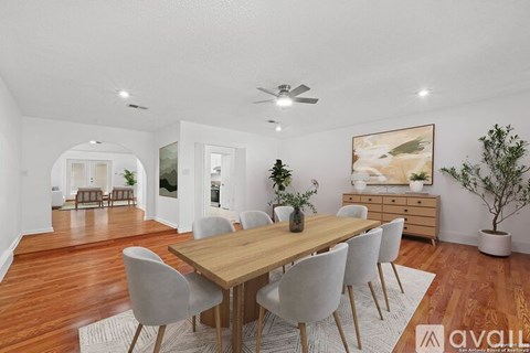 A dining room with a wooden table and grey chairs.