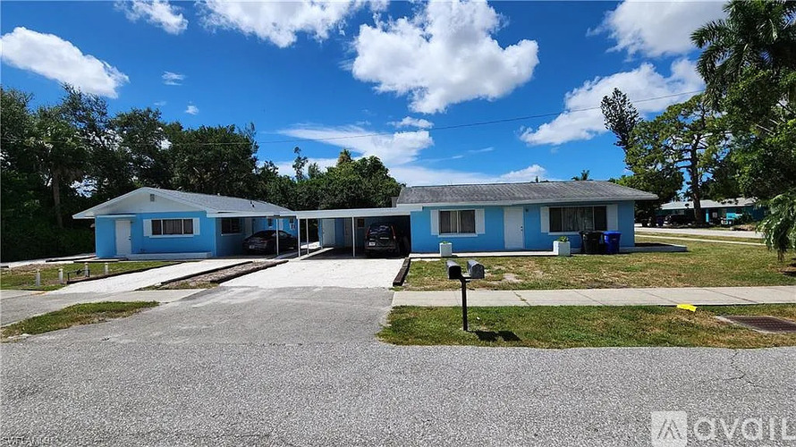 A blue building with a gravel driveway in front.