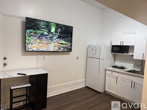 A kitchen with a fridge, microwave, and stove top oven.