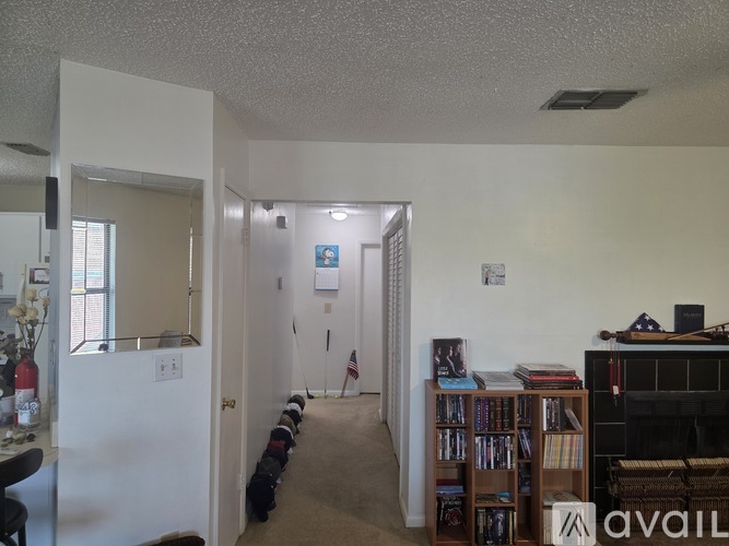 A hallway with a dog on a leash and a fireplace on the right.