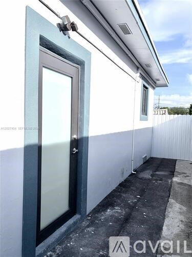 A balcony with a glass door and a white wall.