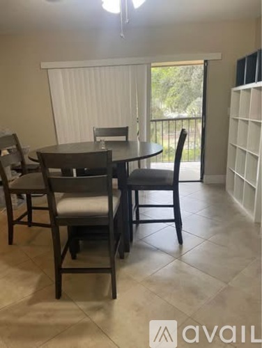 A dining room with a table and chairs.