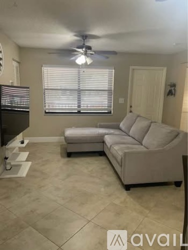 A living room with a grey couch and a television.