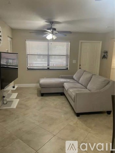 A living room with a grey couch and a television.
