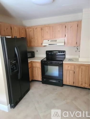 A kitchen with black appliances and wooden cabinets.