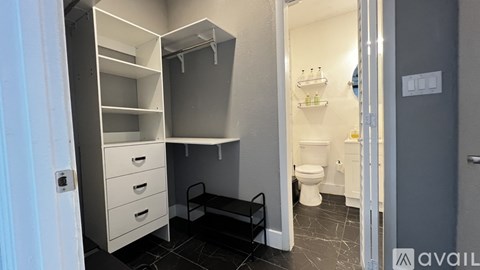 A bathroom with a toilet, sink, and a cabinet with drawers.