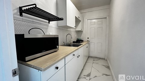 A kitchen with white cabinets and a black oven.