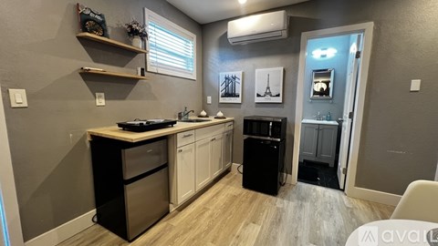 A kitchen with a dishwasher, sink, and a fridge.