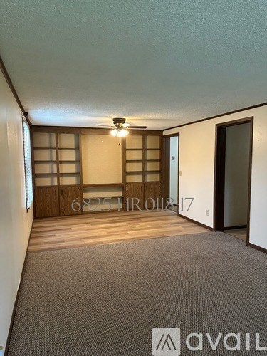 A room with a carpeted floor and a wooden door.