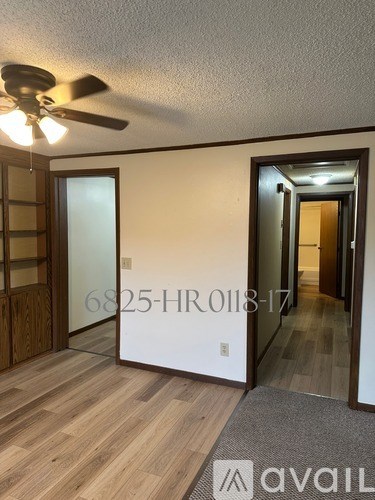 A room with a ceiling fan and a mirror on the wall.