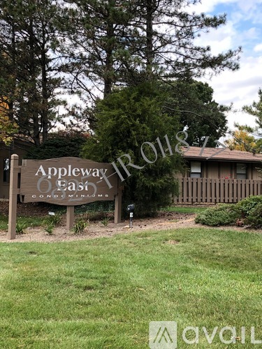 A sign for Appleway Estates is in front of a house and trees.