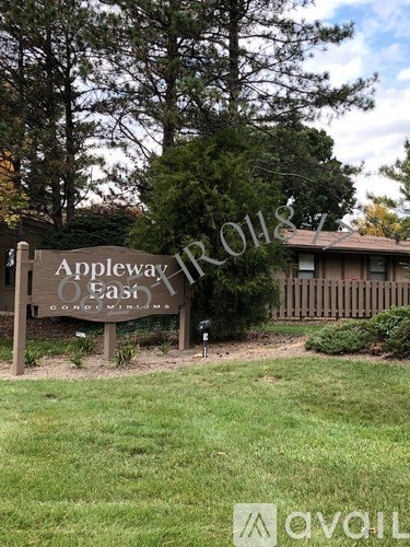 A sign for Appleway Estates is in front of a house and trees.