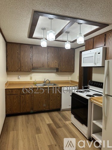 A kitchen with wooden cabinets and a white fridge.
