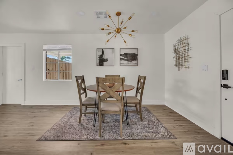 A dining room with a round table and chairs.