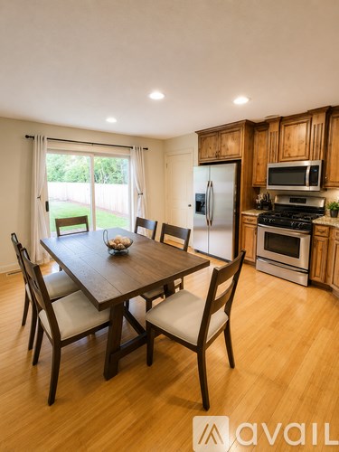 A kitchen with a table and chairs in front of a window.