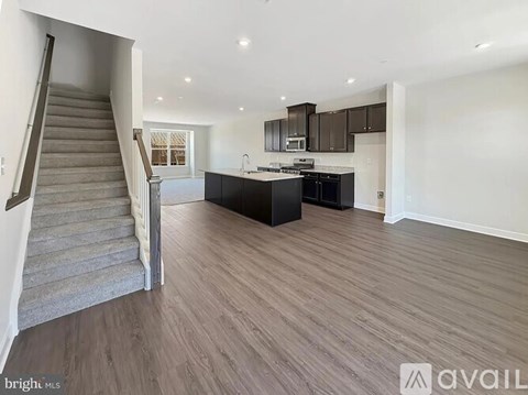 A spacious living room with a staircase leading to the upper floor.