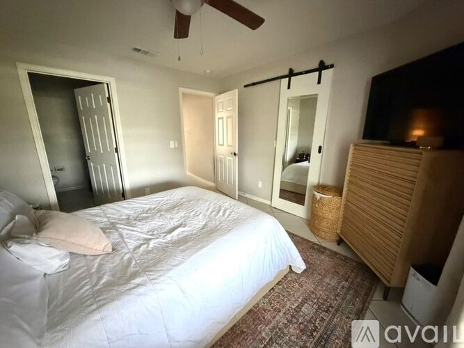 A bedroom with a bed, dresser, and mirror.