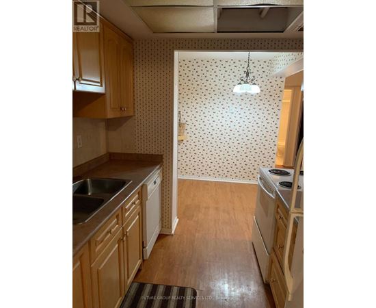 A kitchen with wooden cabinets and a white fridge.