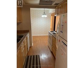 A kitchen with wooden cabinets and a white fridge.