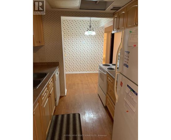 A kitchen with wooden cabinets and a white fridge.