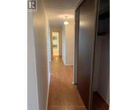 A hallway with wood floors and white walls.