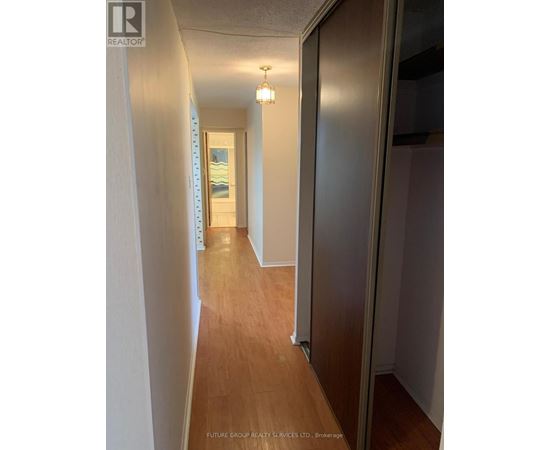 A hallway with wood floors and white walls.