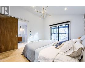 A bedroom with a large bed and a chandelier.