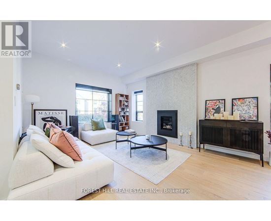 A living room with a white couch and a fireplace.