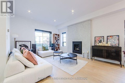 A living room with a white couch and a fireplace.