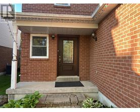 A house with a brown door and a brick wall.