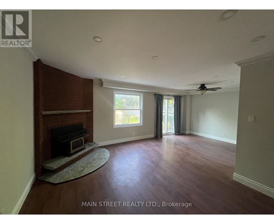 A living room with wood flooring and a fireplace.