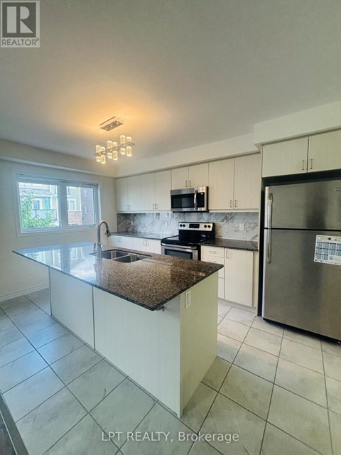 A kitchen with a granite countertop and stainless steel appliances.