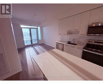 A kitchen with white cabinets and a wooden floor.