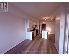 A spacious room with wooden floors and white walls.