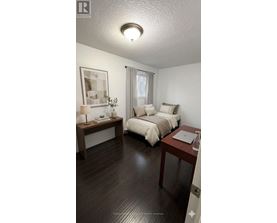 A bedroom with a bed, nightstand, and lamp.