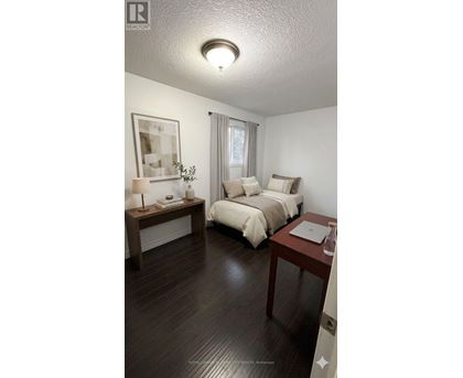 A bedroom with a bed, nightstand, and lamp.