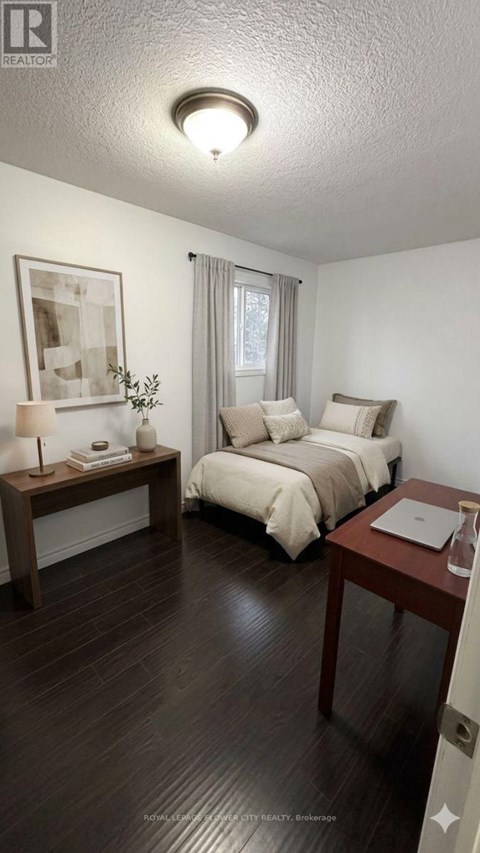 A bedroom with a bed, nightstand, and lamp.