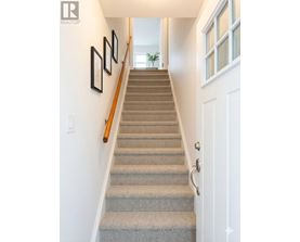 A staircase with a beige carpet and a white door.