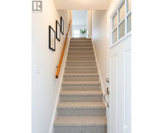 A staircase with a beige carpet and a white door.