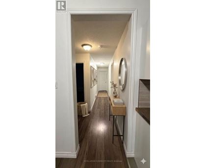 A hallway with a wooden floor and white walls.