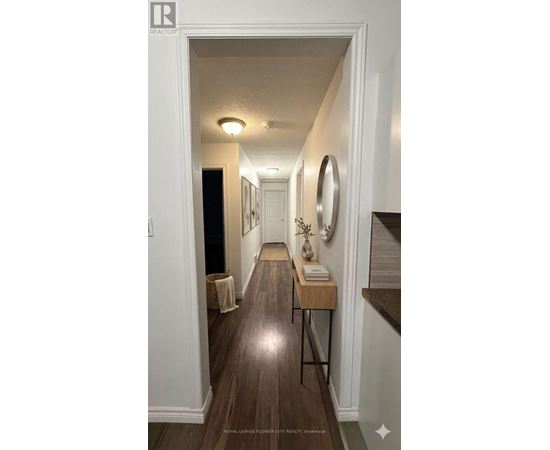 A hallway with a wooden floor and white walls.