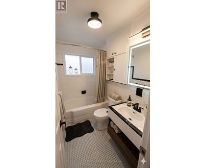 A bathroom with a white tub, sink, and toilet.