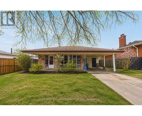 A house with a brown roof and a tree in front of it.