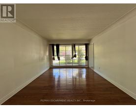 A long hallway with wood floors and white walls.