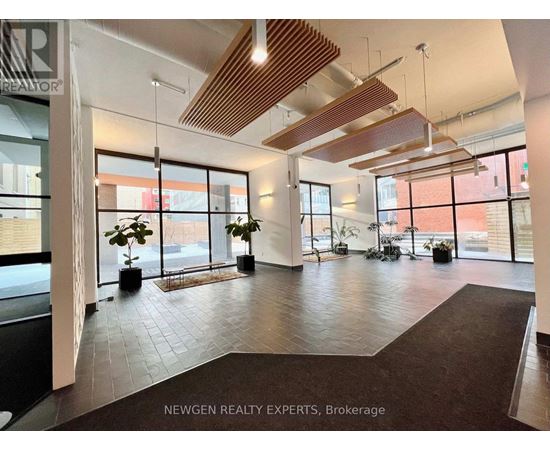 A lobby with a brown carpet and a wooden ceiling.